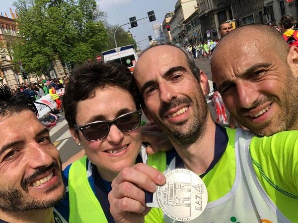 Giangavino Buseddu, Matteo Plaisant, Chiara Pandolfi e Fabio Orrù fotografati con la medaglia al traguardo della Milano Marathon