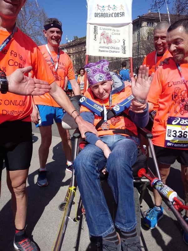 Valerio con la medaglia all'arrivo attorniato dai suoi spingitori