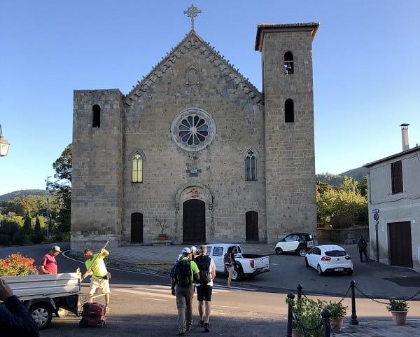si parte: sullo sfondo la chiesa di Bolsena e il gruppo che inizia il cammino